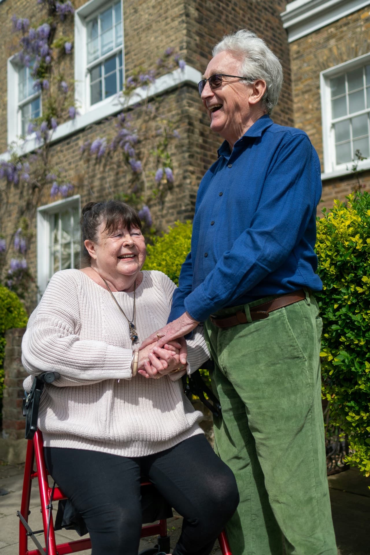 Elderly couple holding hands in a garden