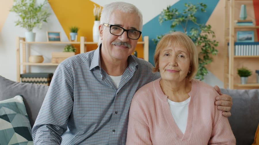 Elderly couple smiling together on a couch